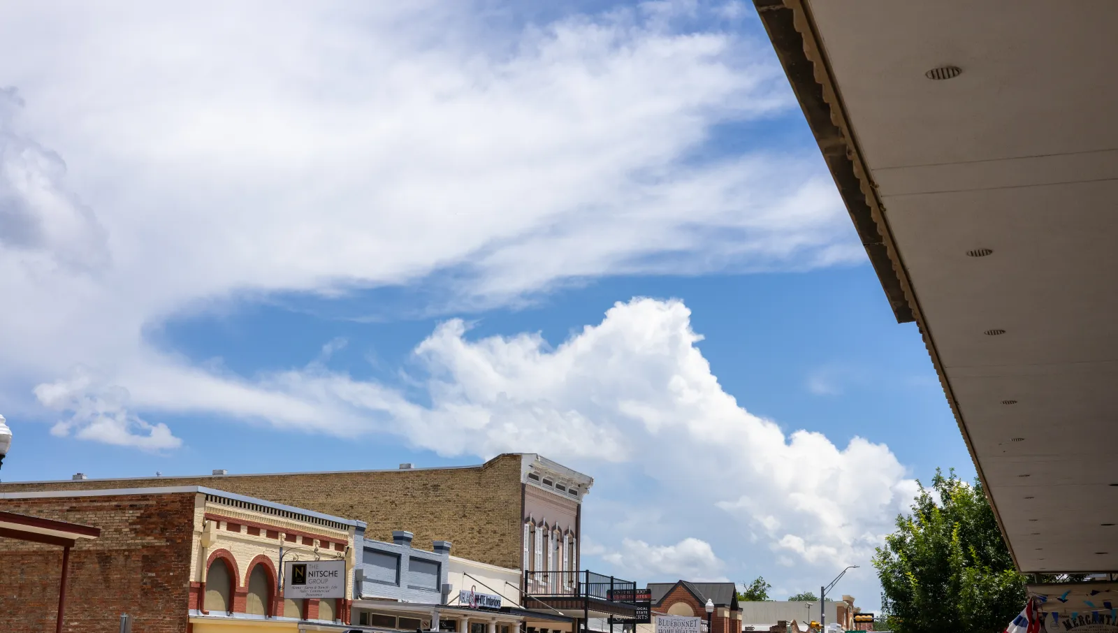 The rooftops of downtown Bastrop's Main Street against a Texas sky